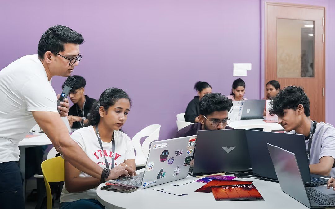 A mentor working through a laptop with students