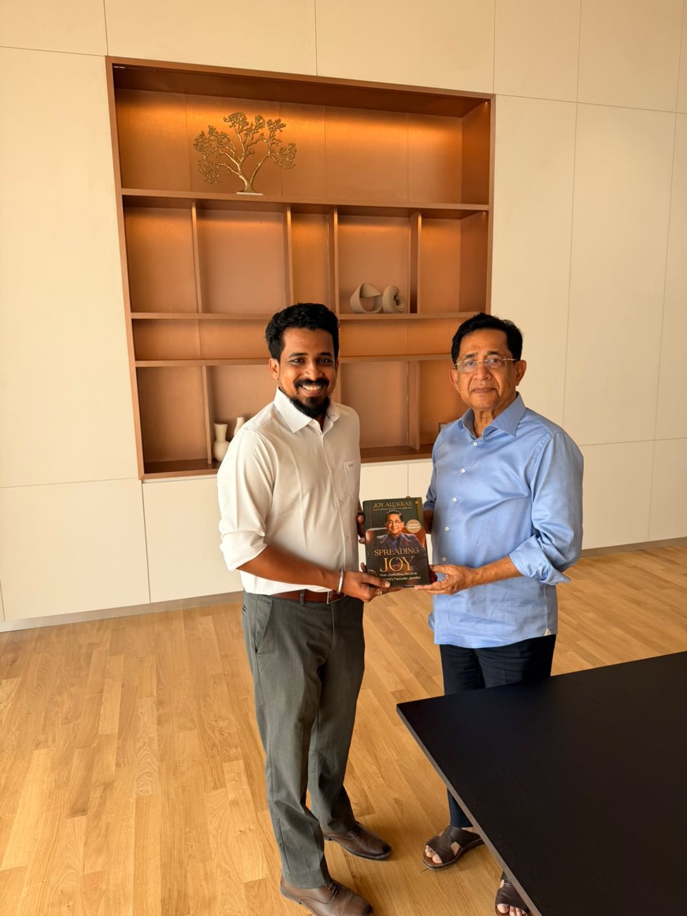 Akshay receiving a book from a guest at SOF